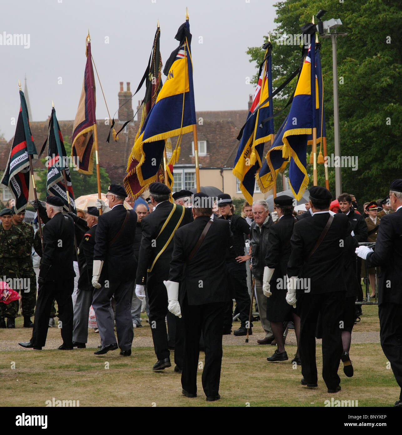 Royal British Legion members parade their standards with black ribbons flying in respect at a funeral service Stock Photo