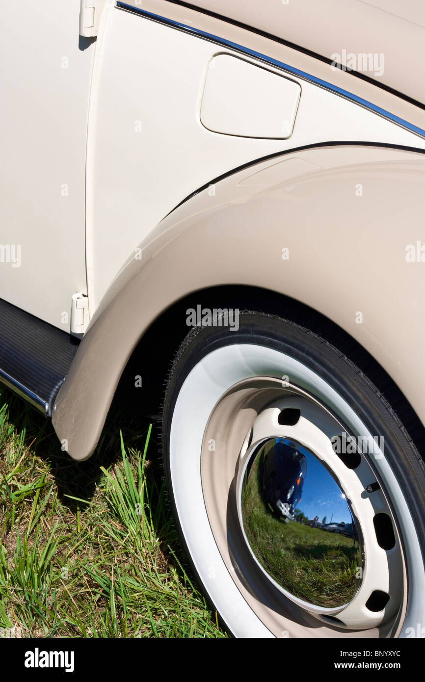 Classic car with steel rims with chrome center caps and whitewall tires Stock Photo