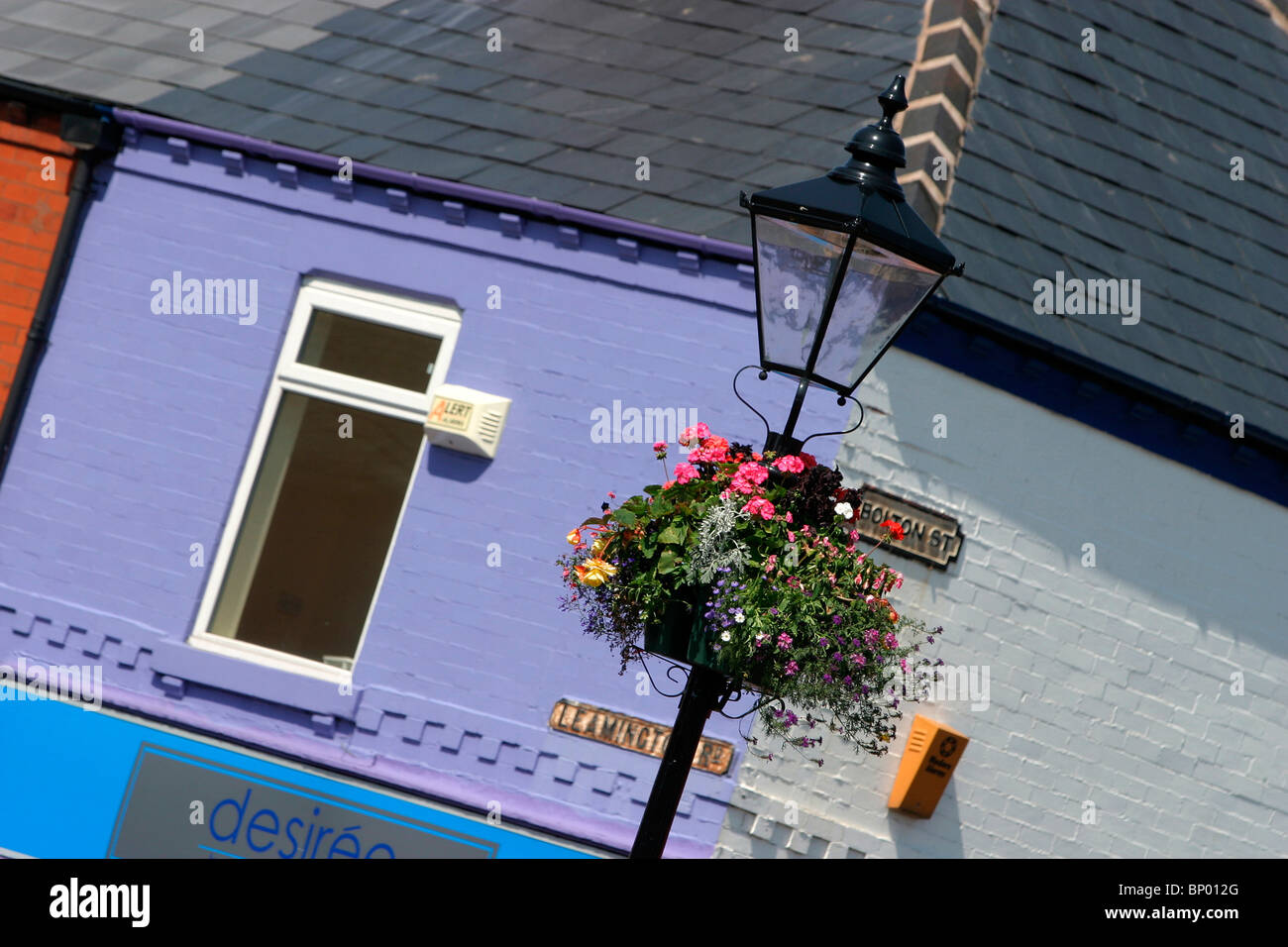 England, Cheshire, Stockport, Reddish, Houldsworth Square, hanging basket and colourfully painted buildings Stock Photo