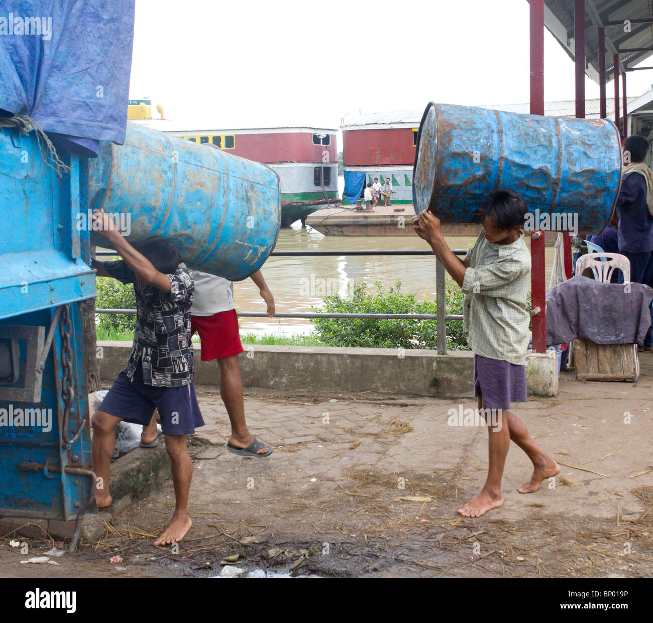 manual labourers carrying empty drums, Yangon docks, Myanmar Stock