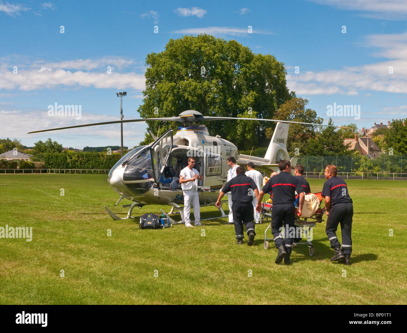 Rescue team carrying patient to Eurocopter EC135 air ambulance Indre