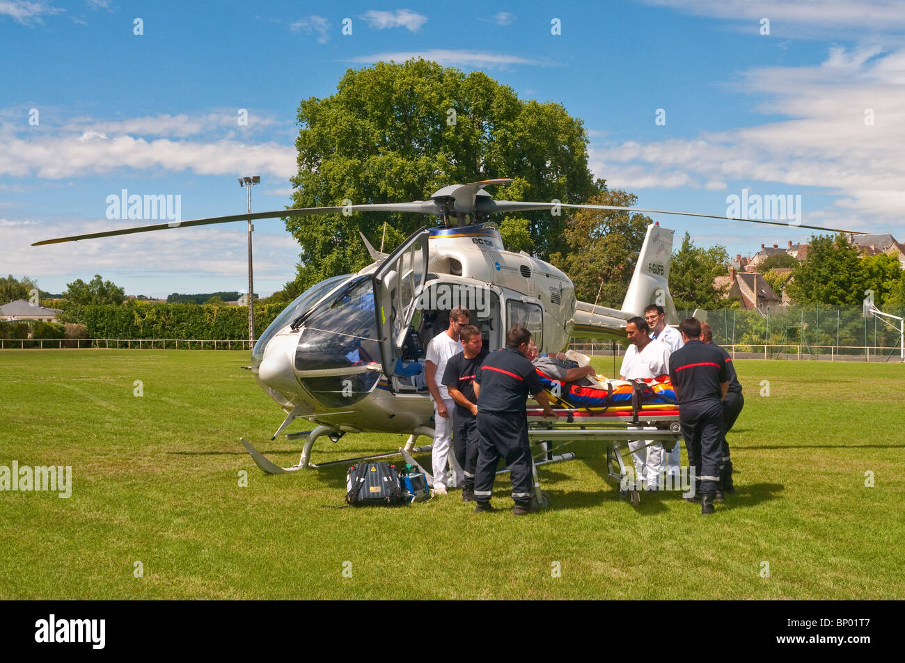 Rescue team carrying patient to Eurocopter EC135 air ambulance - Indre-et-Loire, France. Stock Photo