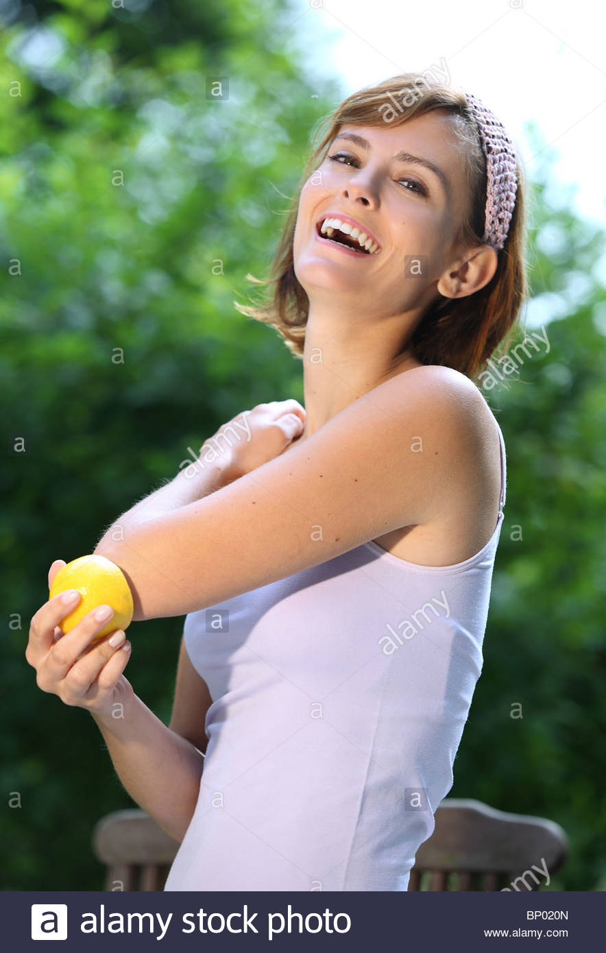woman rubs the elbow with a lemon Stock Photo