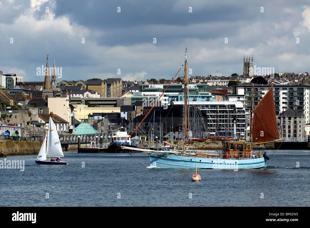 Lugger Ros Alither leaving Sutton harbour Plymouth with the cityscape in the background Stock Photo