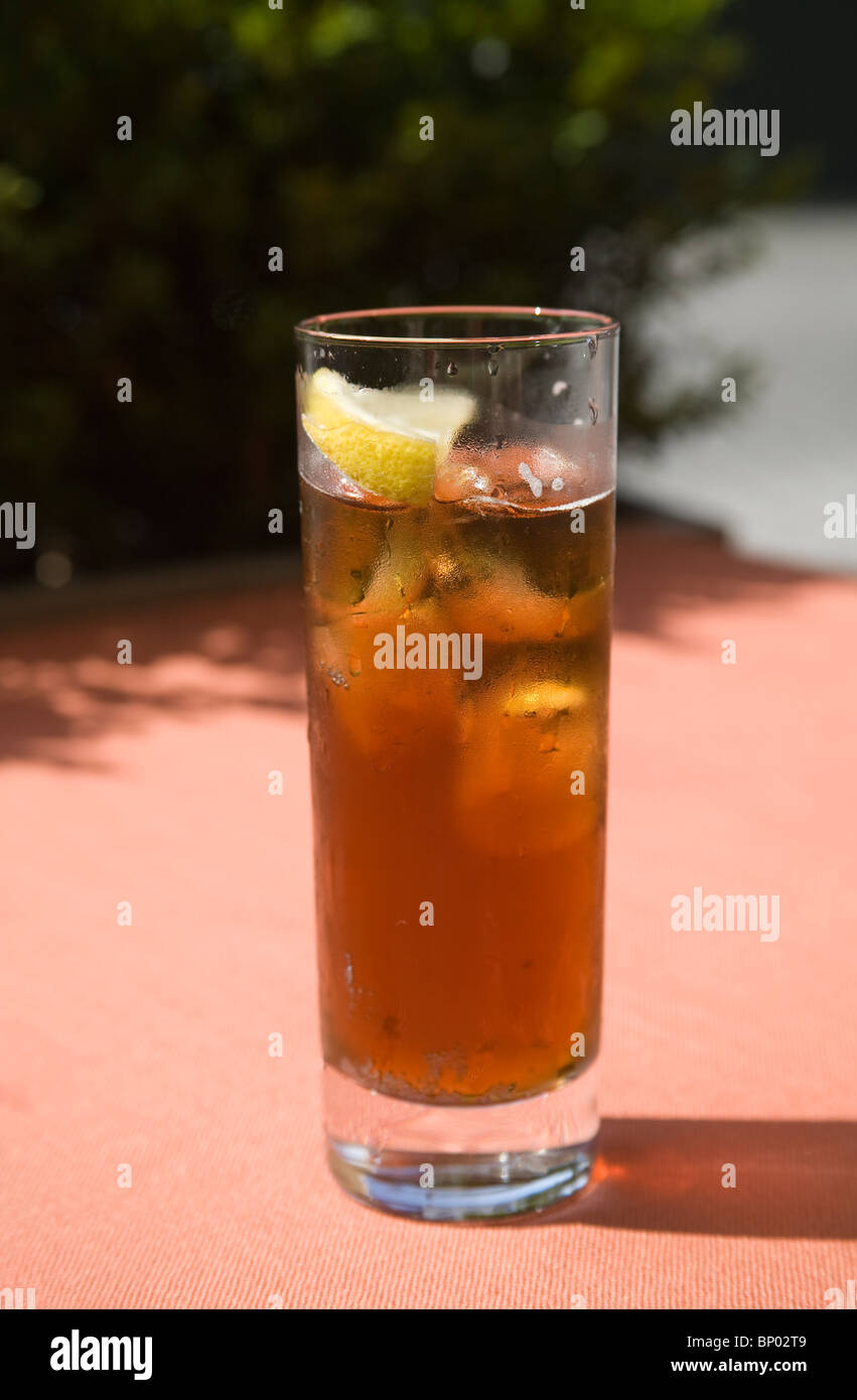 A refreshing glass of iced tea with a slice of lemon and ice cubes Stock Photo