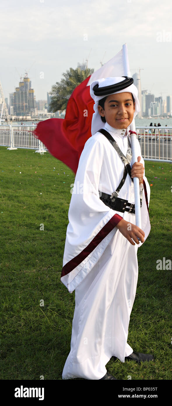 A Qatari boy in full national dress, proudly carries his country's flag on National Day, Dec 18, 2009, Stock Photo