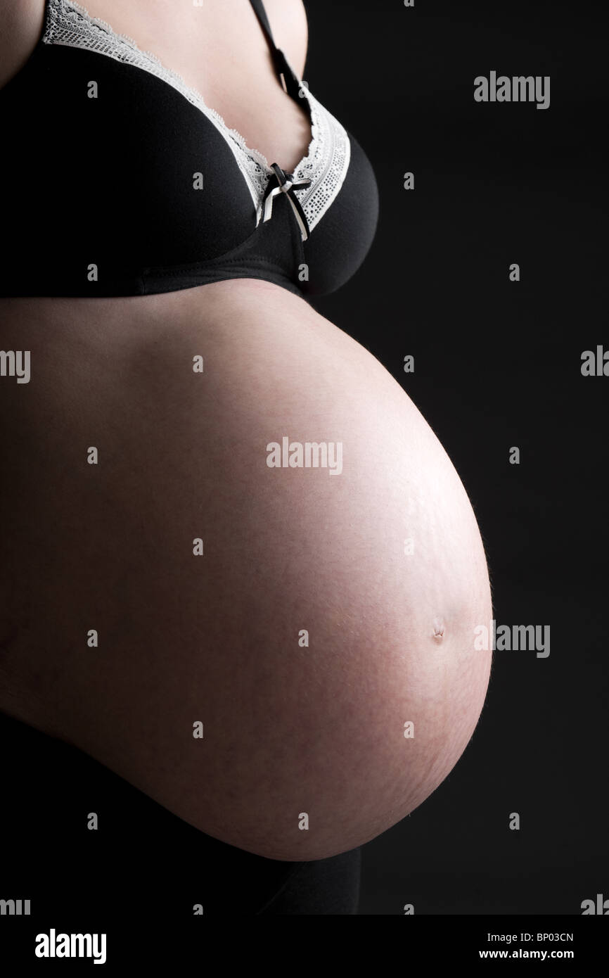 Beautiful Low Key Shot of a Pregnant Woman's Bump Stock Photo
