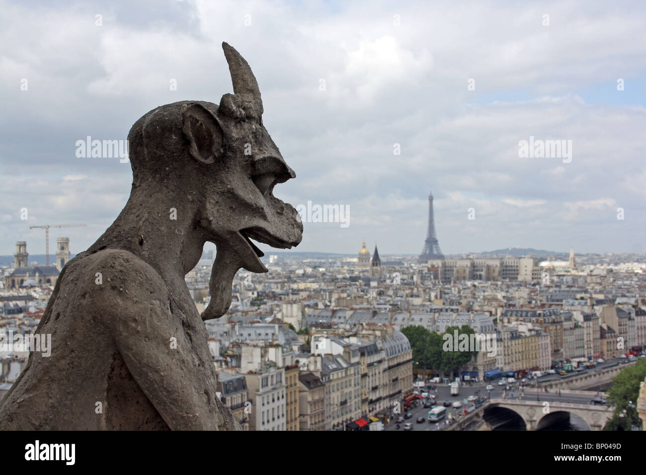 Notre Dame Cathedral, Paris.  Chimera 17, horned goat demon, on the balcony, with Eiffel Tower in the background. Stock Photo