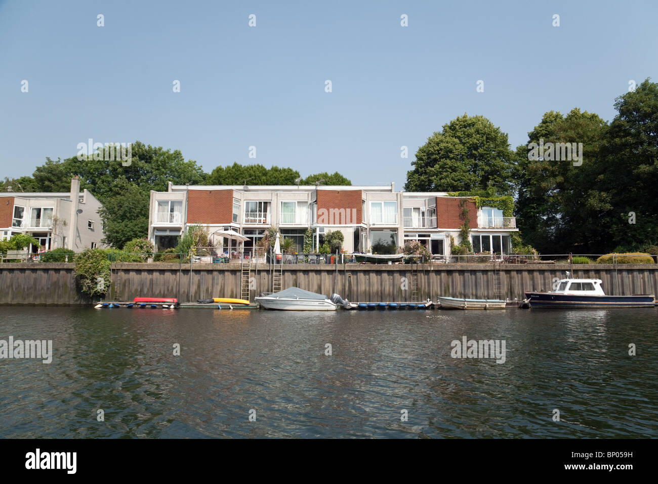 A house on the river Thames with boats moored, Eel Pie island, Twickenham, Richmond, London, UK Stock Photo