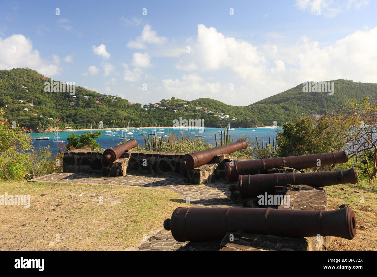 Cannons on hill overlooking the harbour of Bequia Island, St. Vincent in the Caribbean Stock Photo