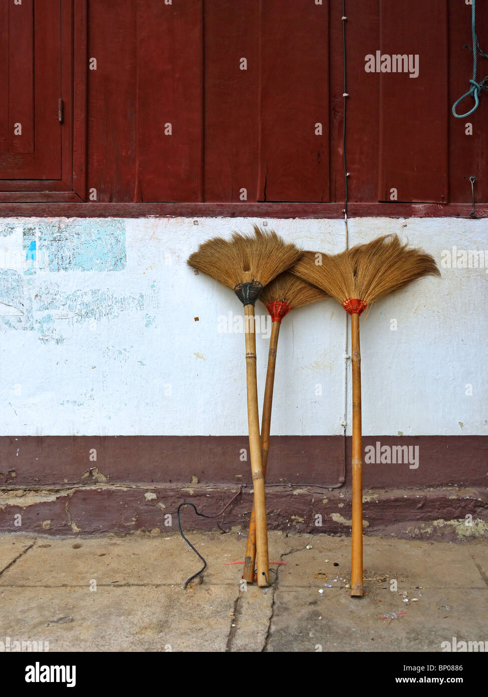 Brooms near the house wall in Luang Prabang, Northern Laos Stock Photo
