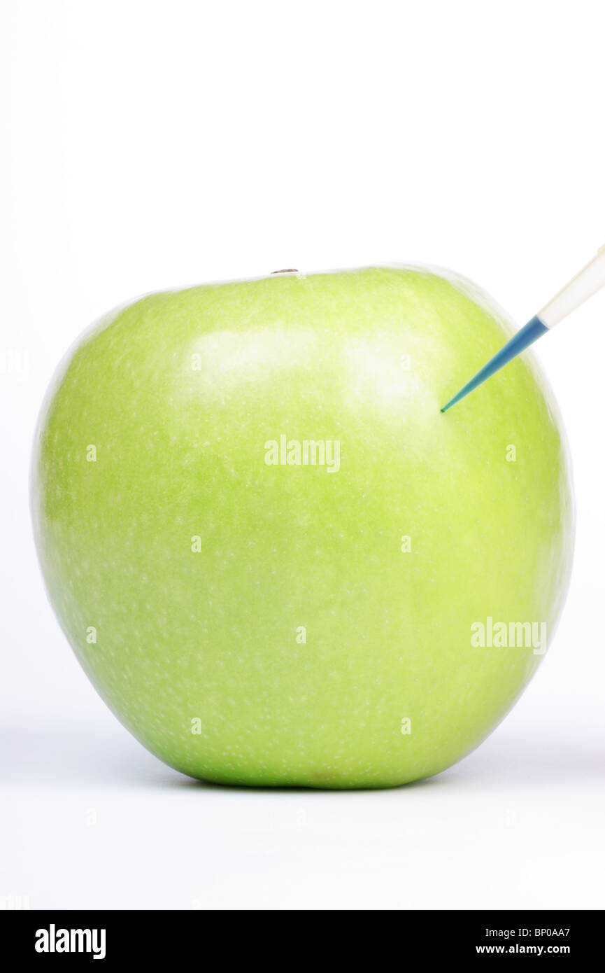 Blue liquid being injected into a Granny Smith. Studio shot. Stock Photo