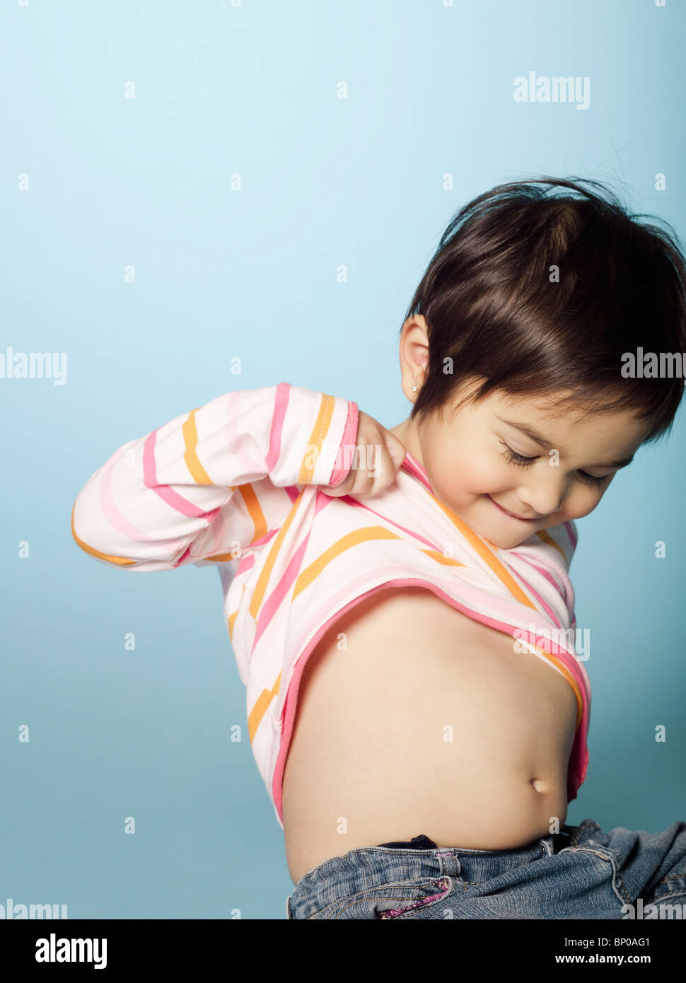 Little girl lifting her sweater Stock Photo Alamy
