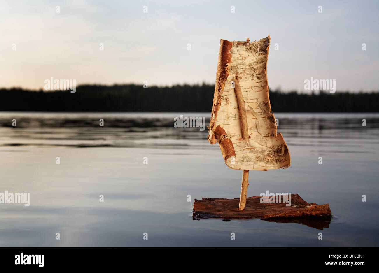 Bark boat on a lake at sunset Stock Photo