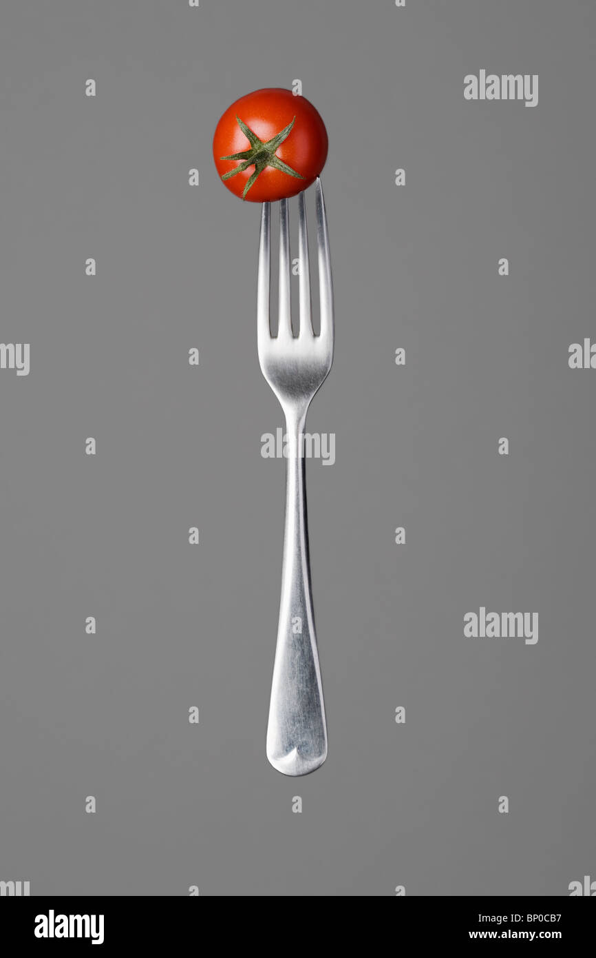 Fork with red tomato Stock Photo