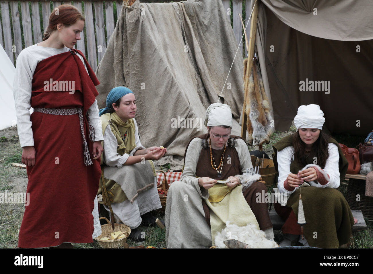 Women spin wool at Finland's biggest Viking Market Festival and re-enactment camp at Kvarnbo on land archipelago Stock Photo