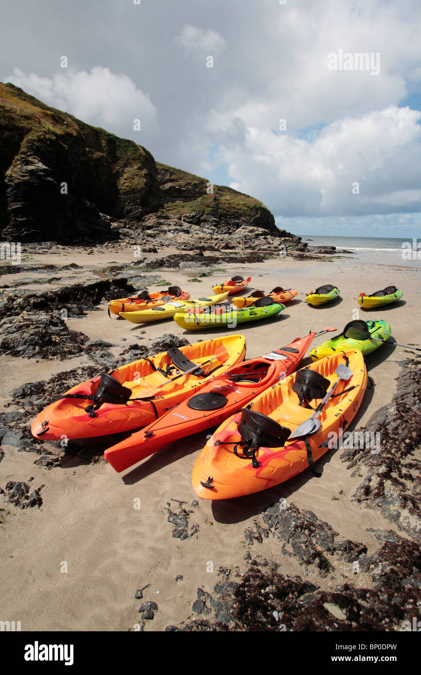 England, Cornwall, Port Gaverne. Sea kayaks hauled up on the beach at low tide Stock Photo Alamy