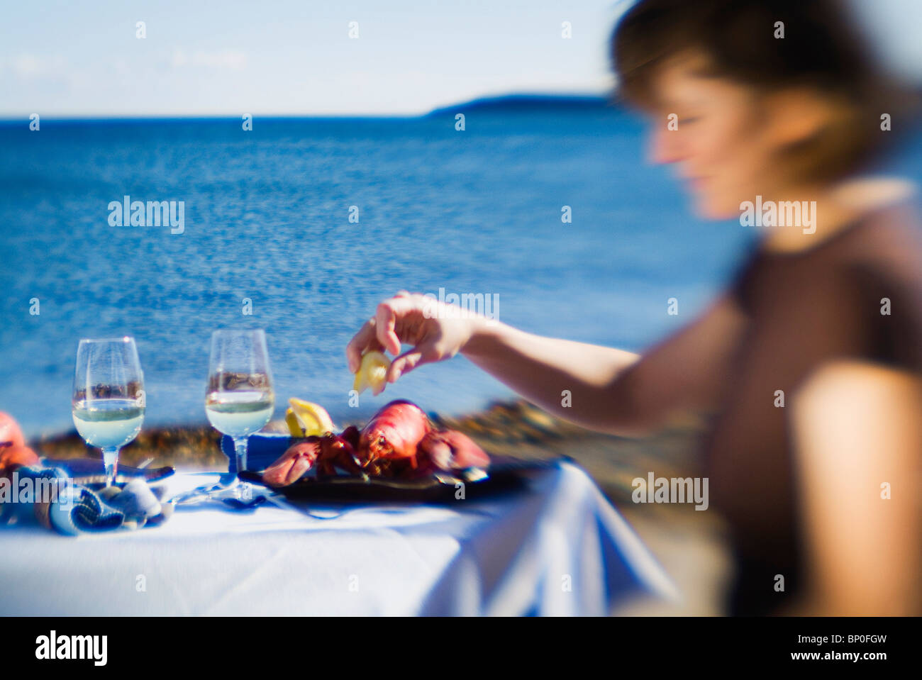 Woman eating lobster on seaside Stock Photo Alamy