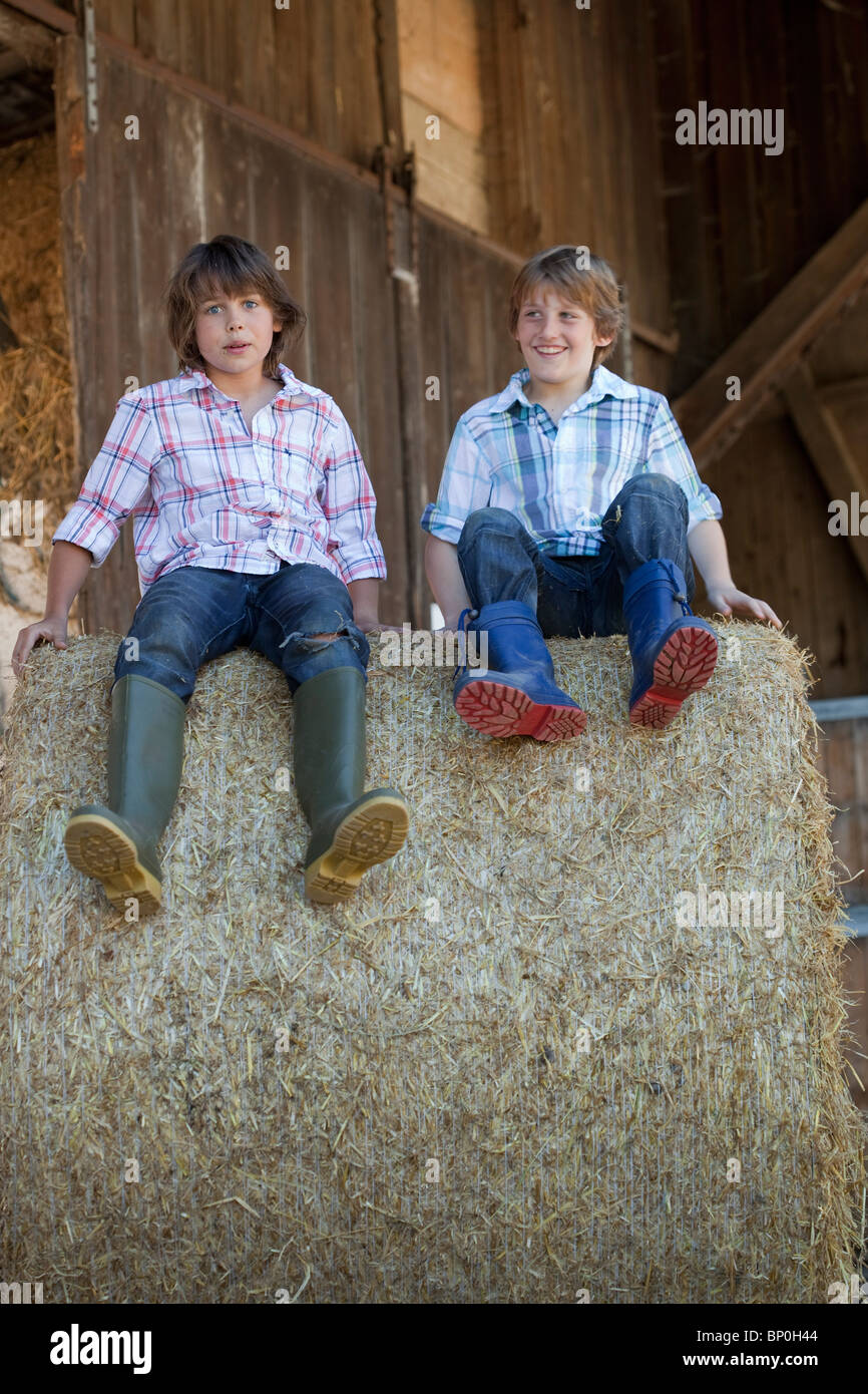 Two boys on haybale Stock Photo