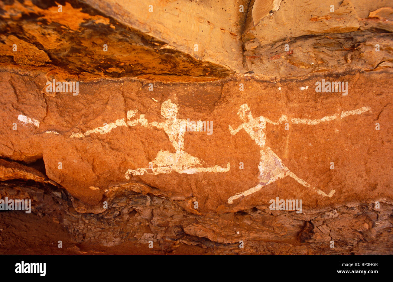 Libya, Fezzan, Jebel Akakus. A pair of running figures painted onto the walls of Uan Muhuggiag, one of Wadi Teshuinat's caves. Stock Photo
