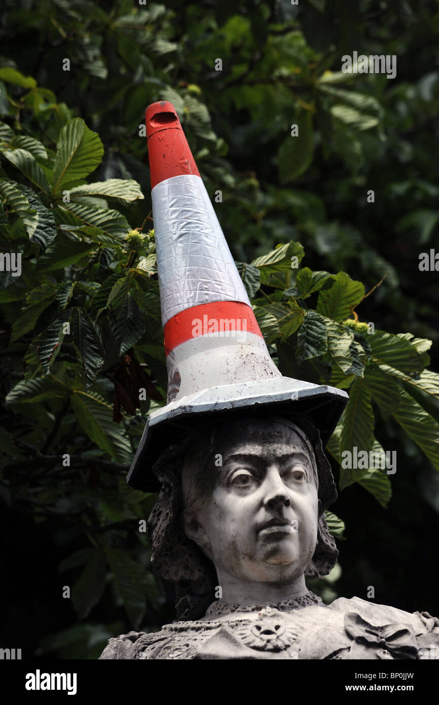A statue of Queen Victoria in Brighton with a traffic cone stuck on its