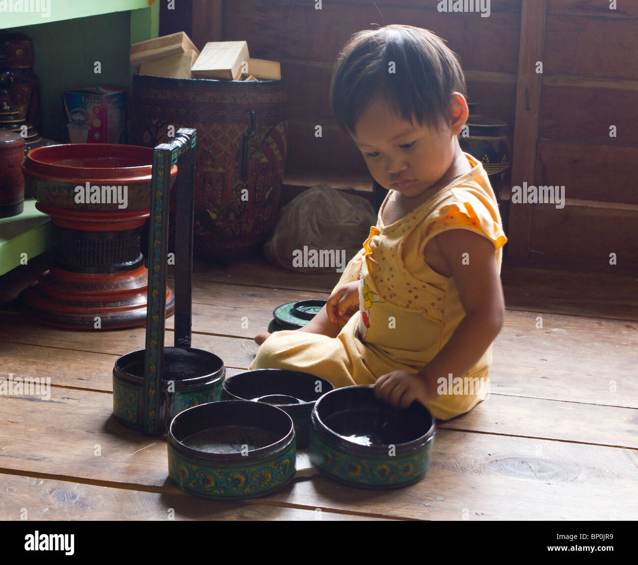 little girl playing with tourist souvenirs at shop in Nam Pan village on Inle Lake in Myanmar Stock Photo