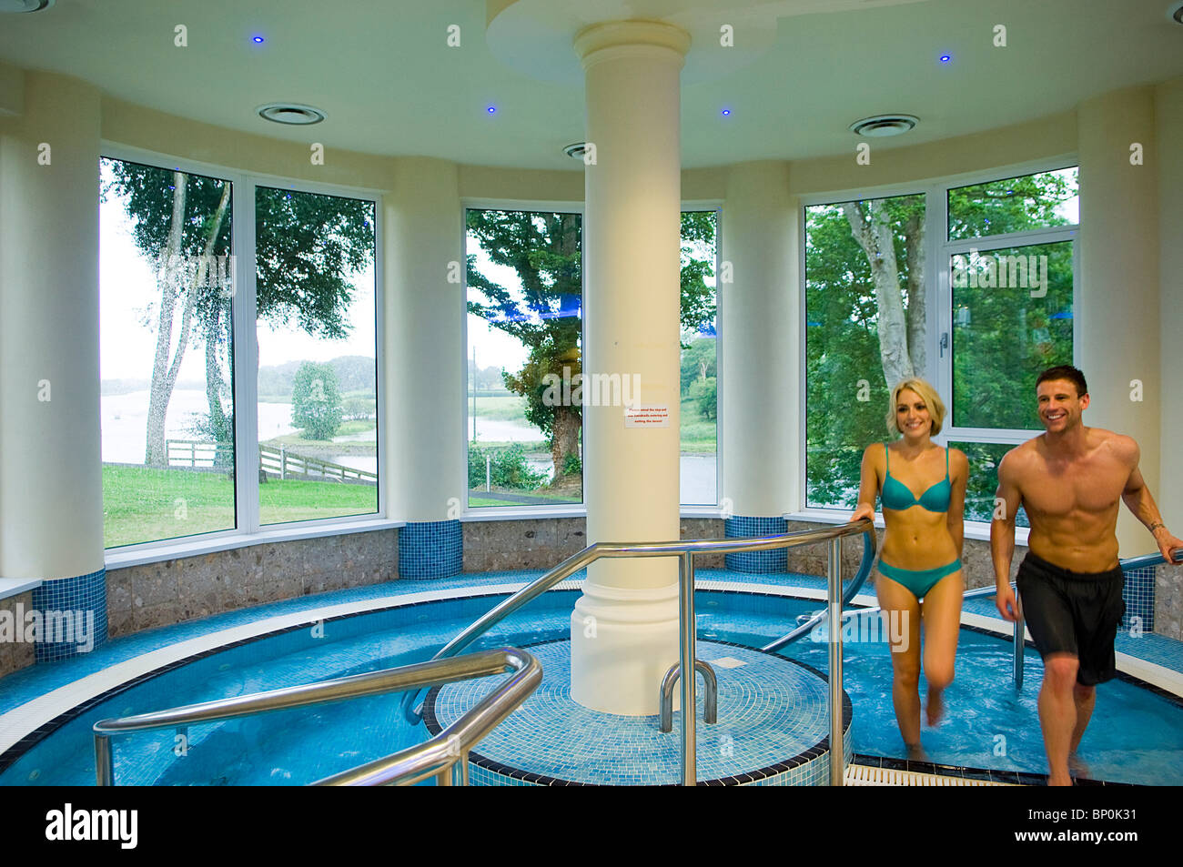 Northern Ireland, Fermanagh, Enniskillen. Couple walk out of the jacuzzi in the Health Spa at Killyhevlin Hotel. (MR) Stock Photo
