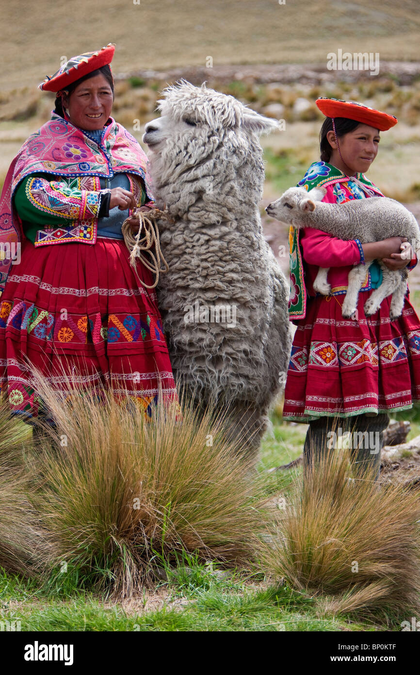 Peru, Females with an alpaca and lamb at Abra La Raya, the highest point (4318m) on the Andean Explorer train (Cusco-Puno) Stock Photo