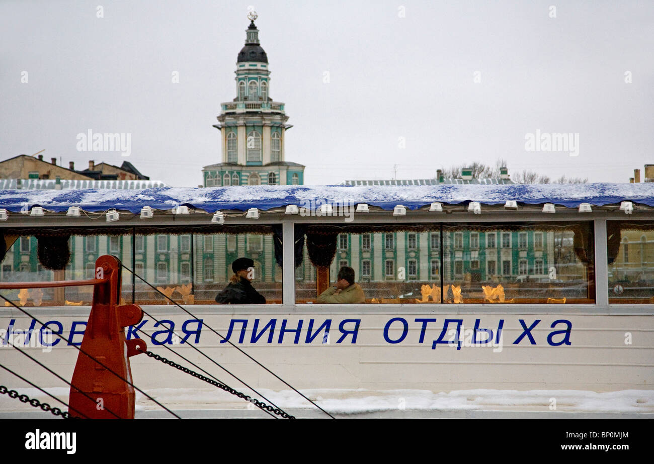 Russia, St. Petersburg; A restaurant-ship anchored on the Neva River with the 'Kunstkamera' behind. Stock Photo