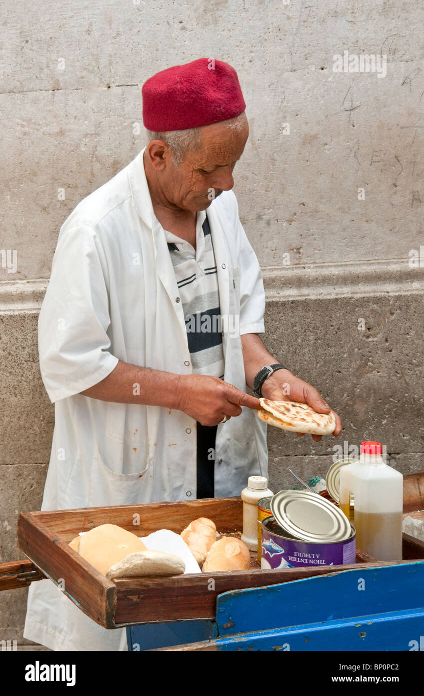 Food vendor slicing Tunisian bread in Souk El Kachachine of the Old Town Tunis Medina Stock Photo