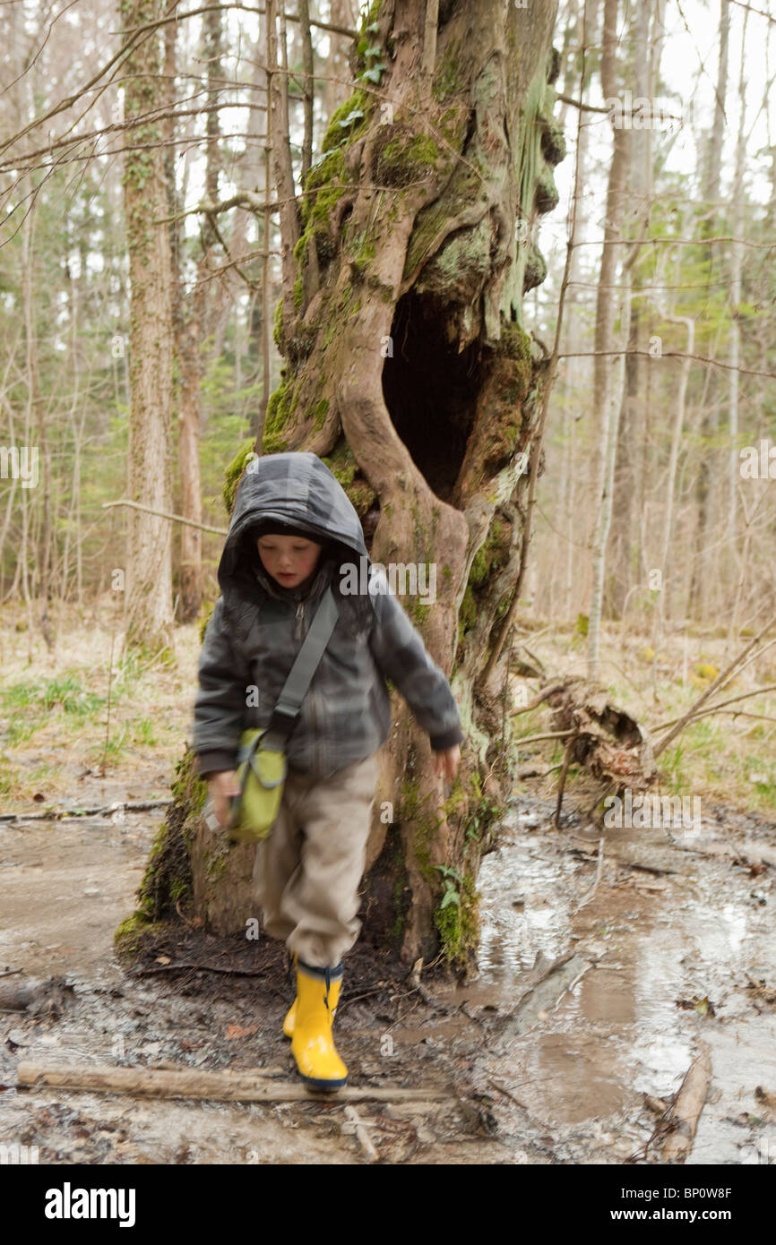 Boy sloshing through mud in a forest Stock Photo