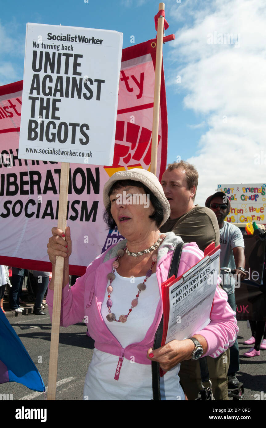 BRIGHTON, ENGLAND, AUGUST 7 2010 - A woman marches in the parade at Brighton Pride carrying a 'Socialist Worker' banner. Stock Photo