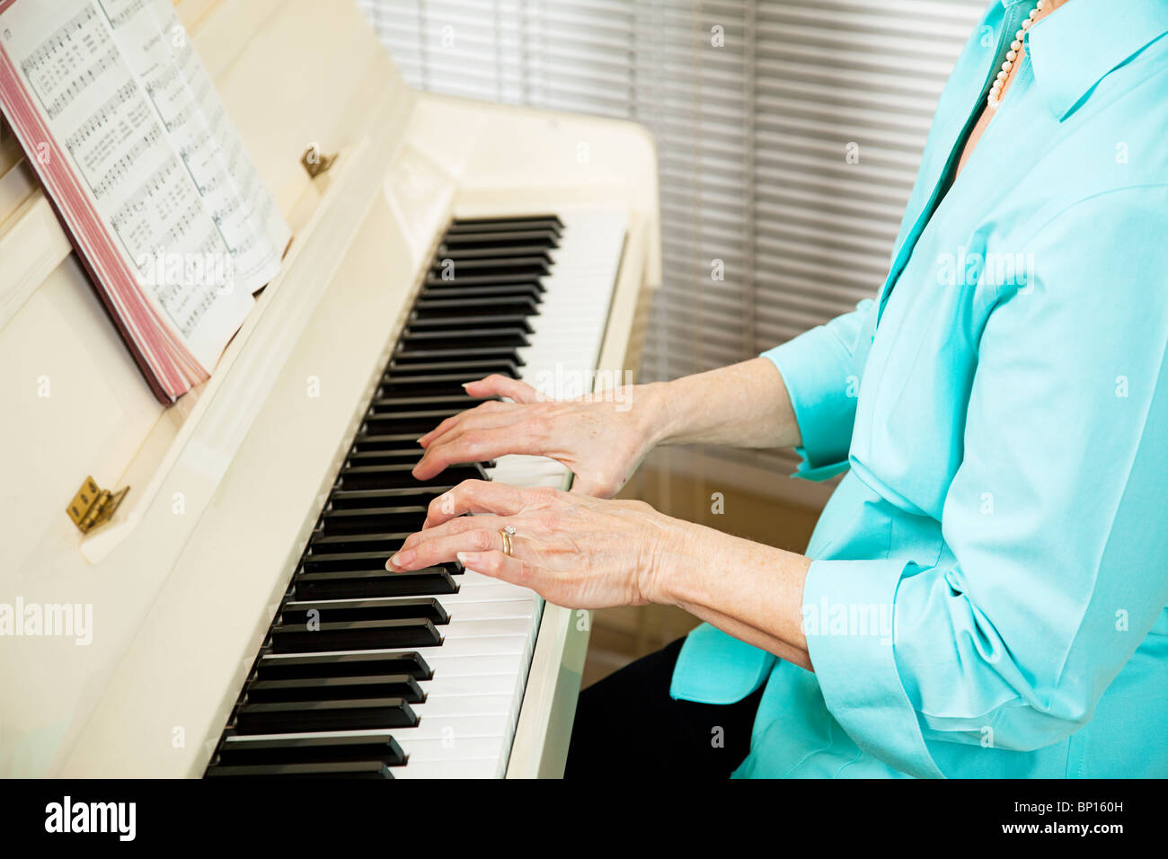 Closeup of a pianists hands as she plays a hymn at church. Shallow depth of field. Stock Photo