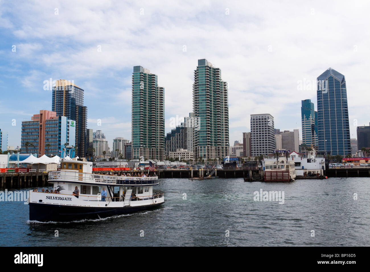 Tour boat with tourists departing the dock and heading out for sightseeing on San Diego Bay in California Stock Photo