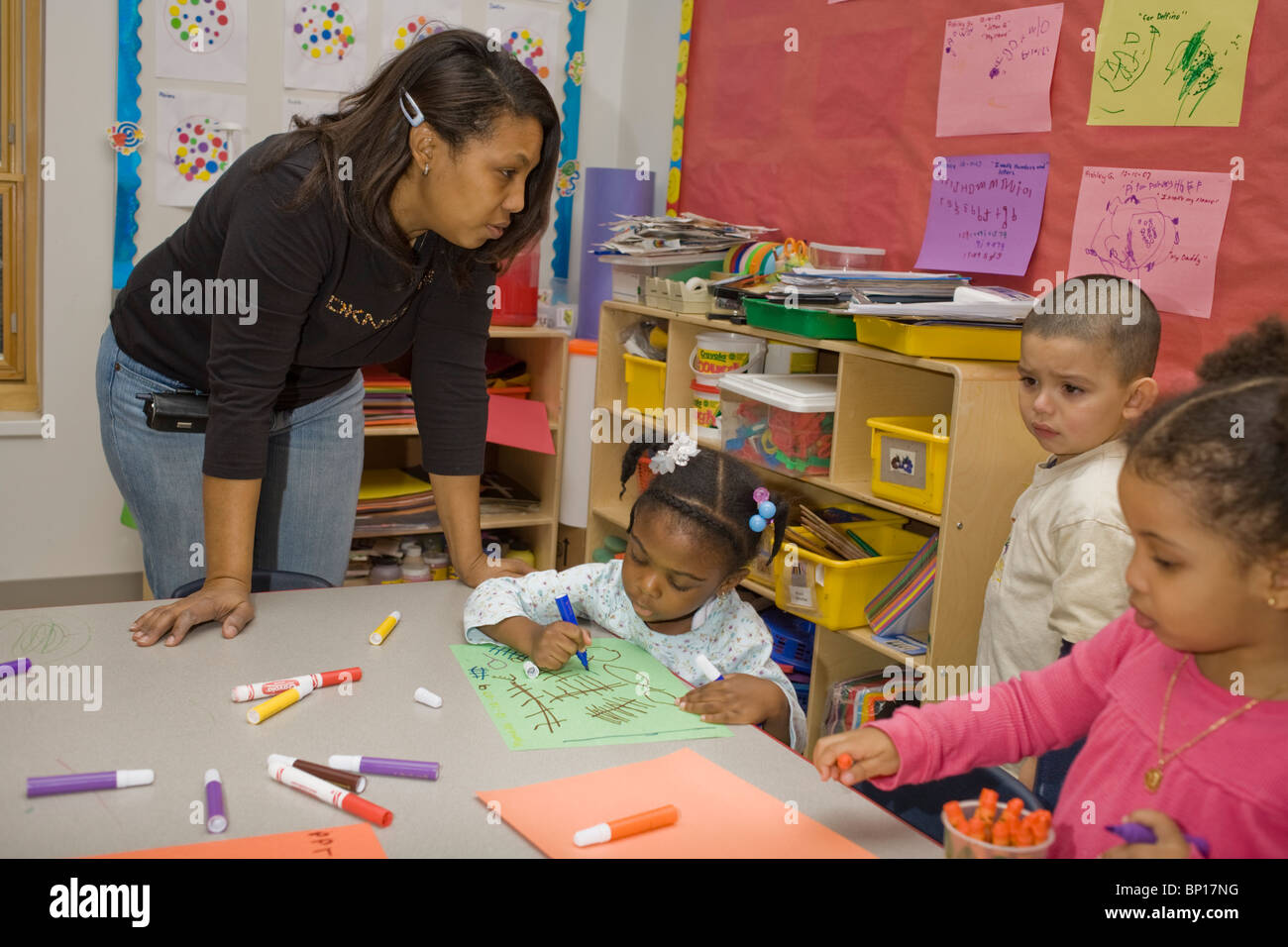 African-American preschool teacher and students in the classroom, Stock Photo