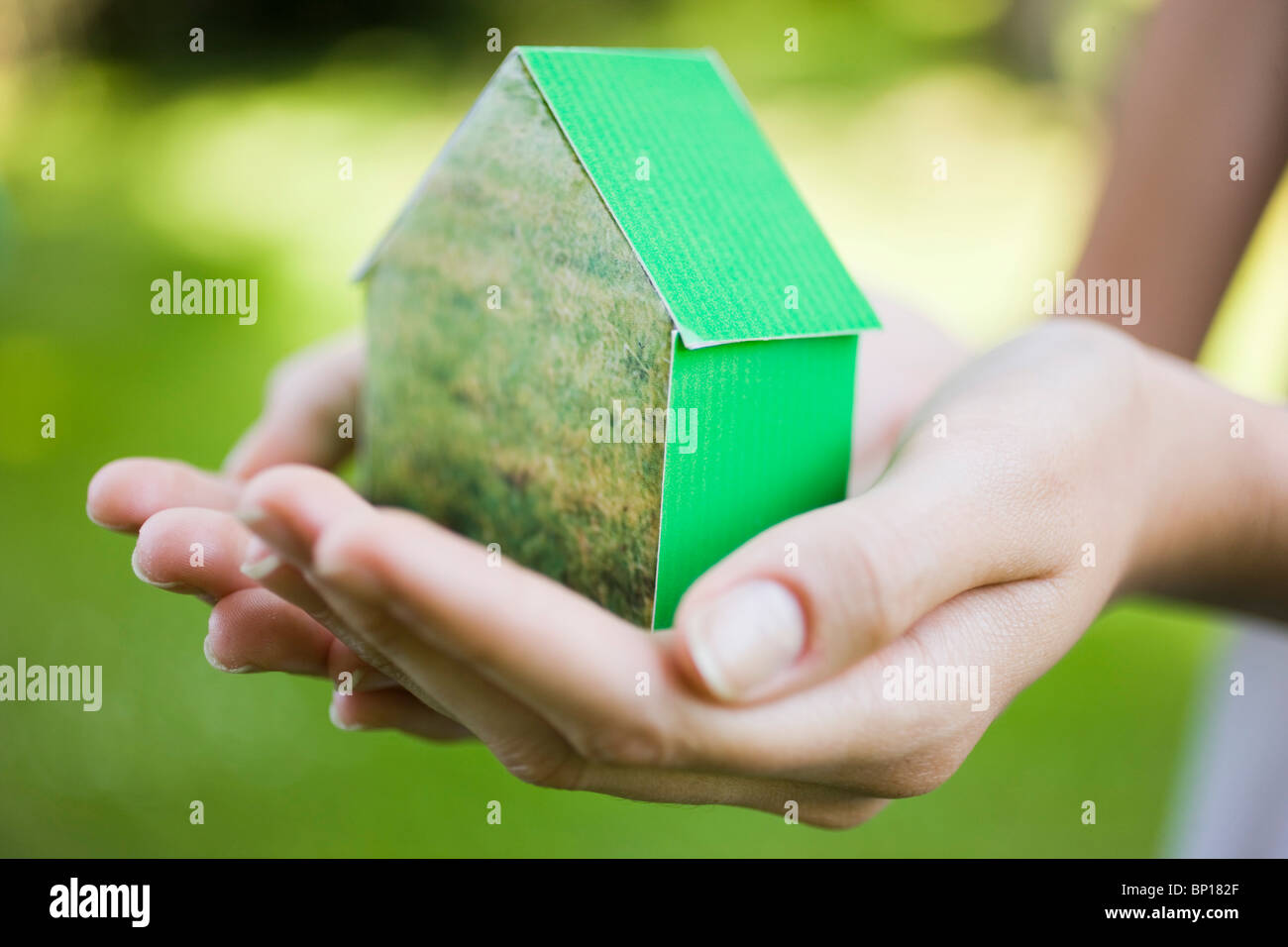 Young woman holding green model house Stock Photo