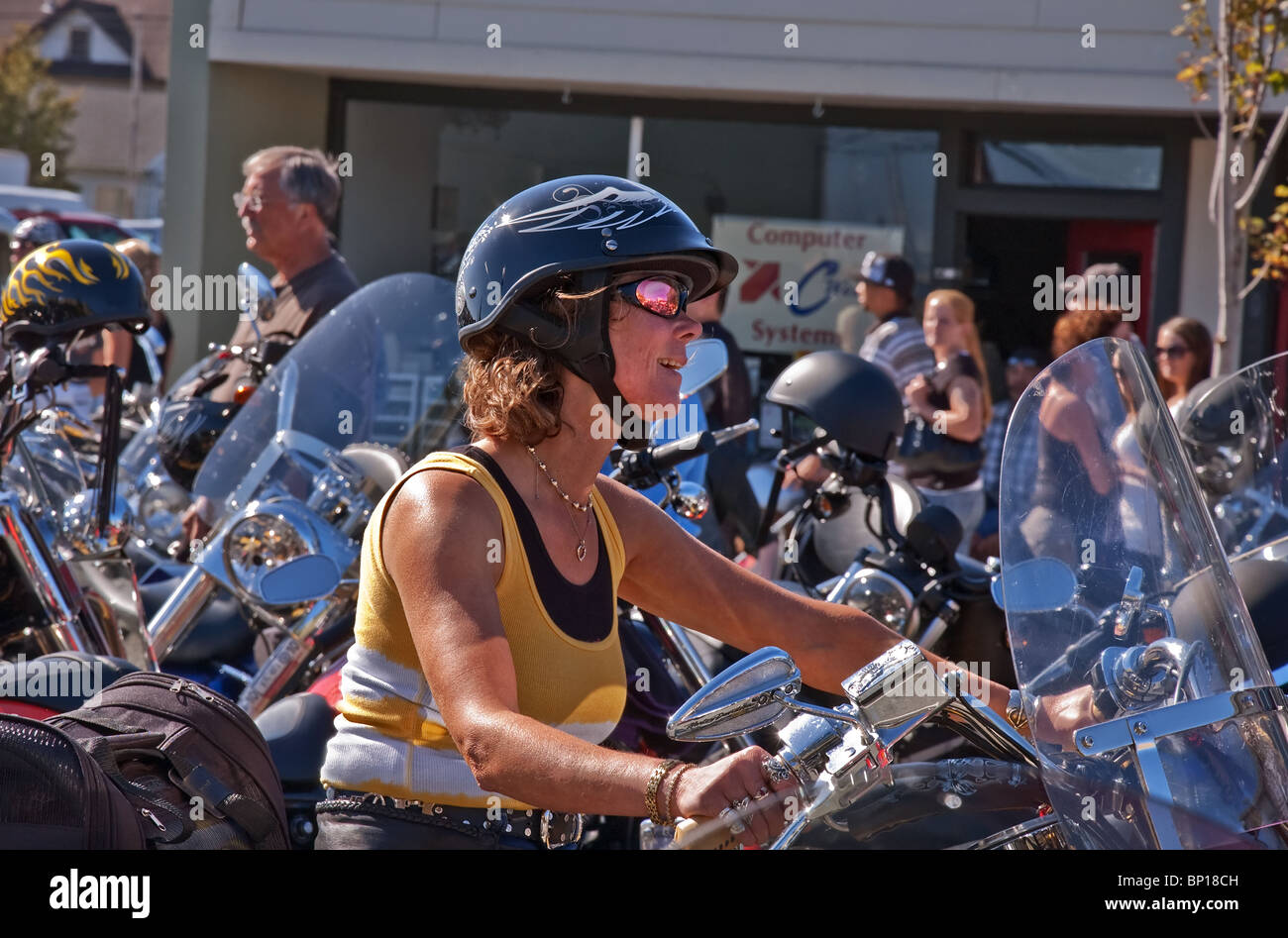 This unidentified Caucasian woman is smiling and confident as she rides her motorcycle at the annual Oyster Run motorcycle rally Stock Photo