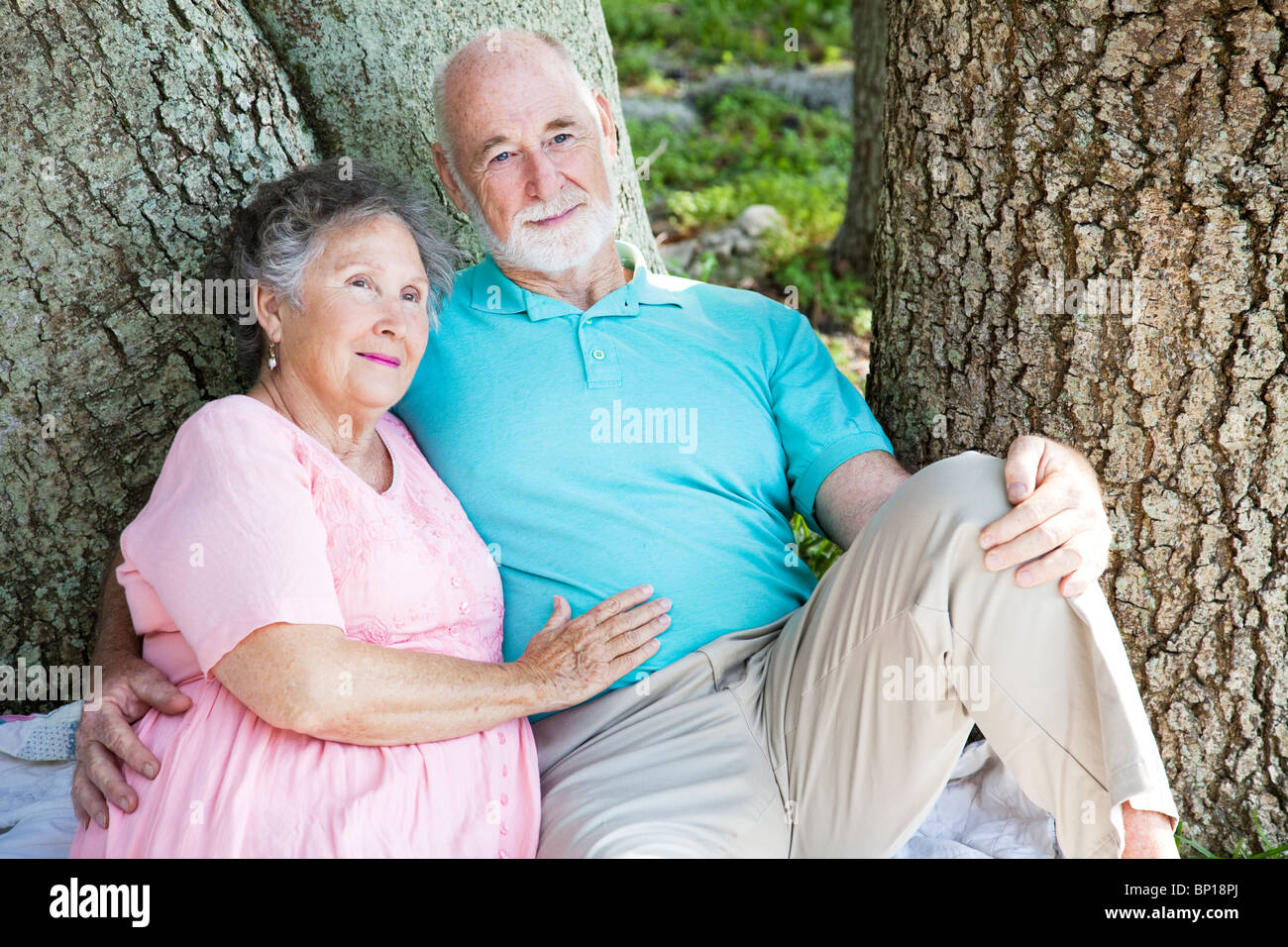 Senior couple relaxing together in the park under a tree Stock Photo ...