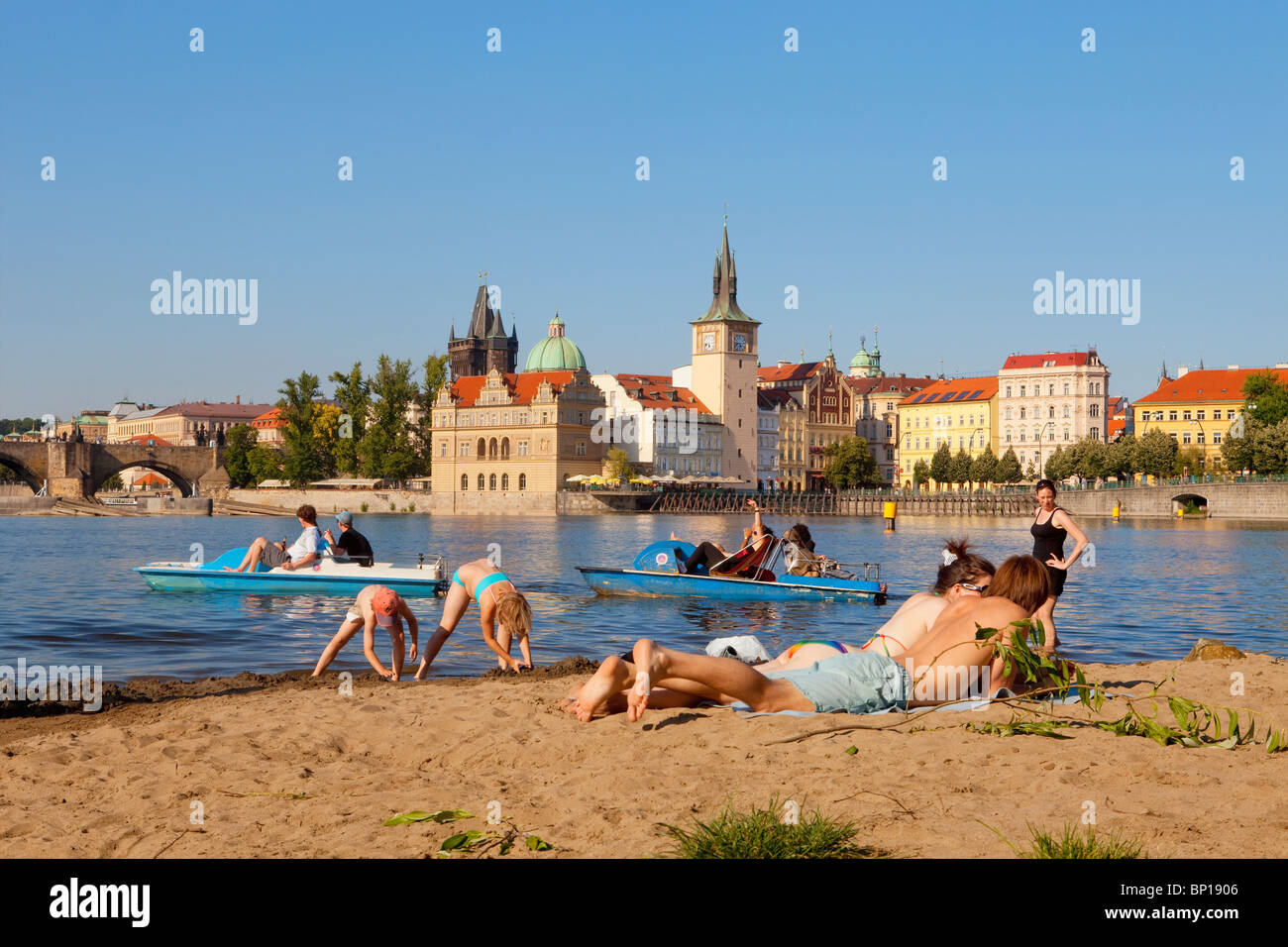 prague - people enjoying summer strelecky island beach - old town in background Stock Photo