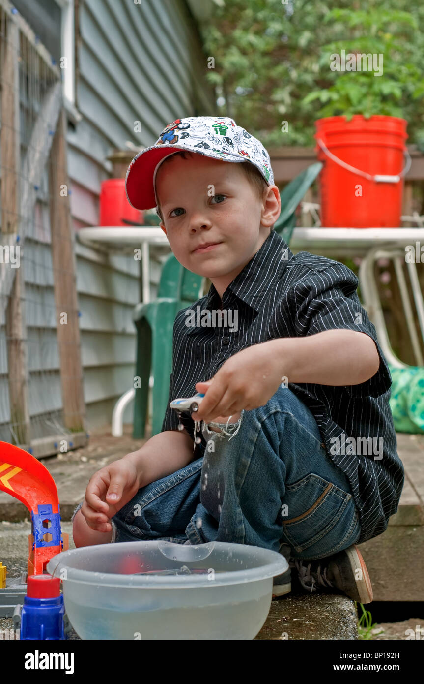 This cute 6 year old Caucasian boy with freckles & wearing a cap and