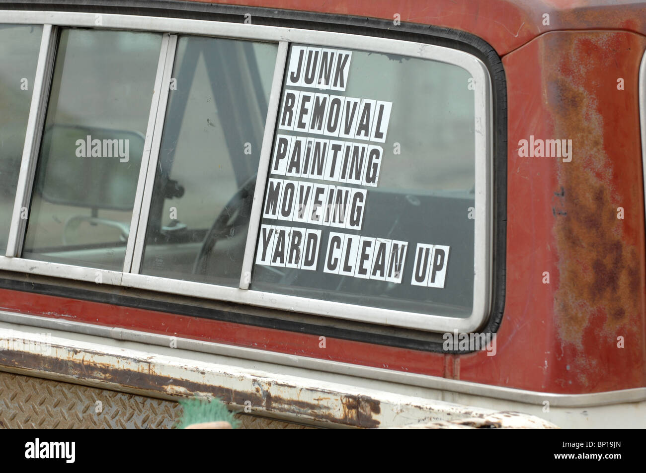 Sign with misspellings on the back of an entrepreneur's pickup truck 'JUNK REMOVAL PAiNTING [sic] MOVEING [sic] YARD CLEAN UP' Stock Photo