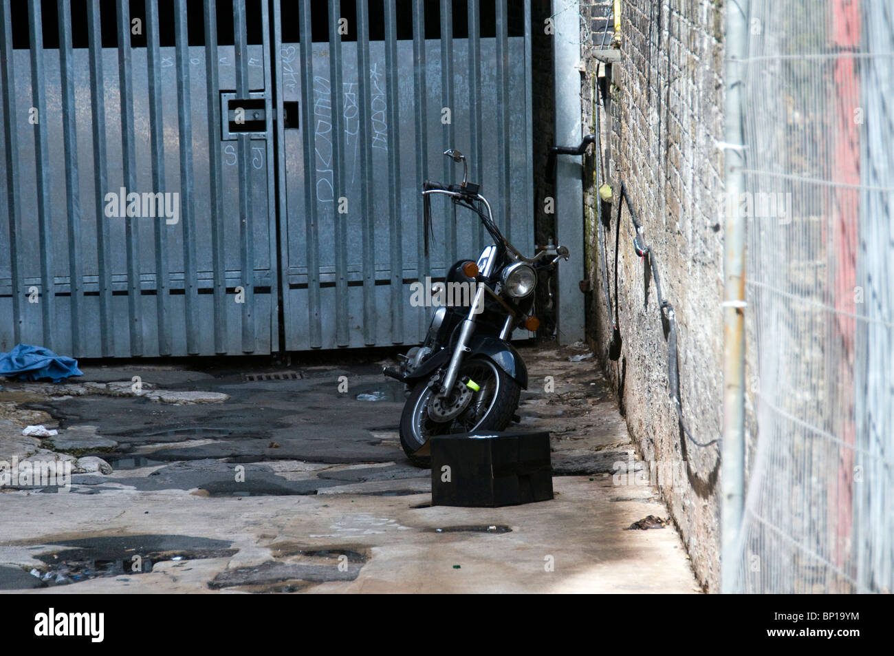 Motorbike parked down an alleyway Stock Photo