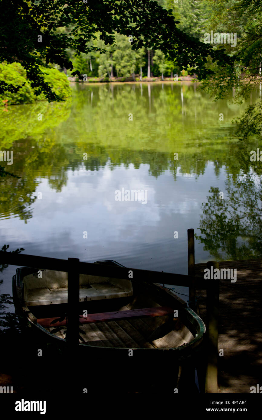A rowing boat moored at the side of a tranquil small lake Stock Photo ...