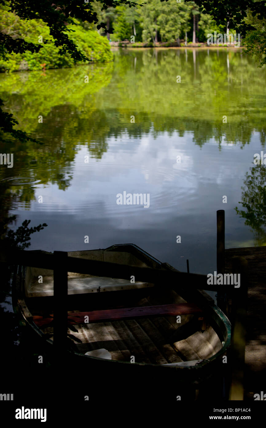 A rowing boat moored at the side of a tranquil small lake Stock Photo ...