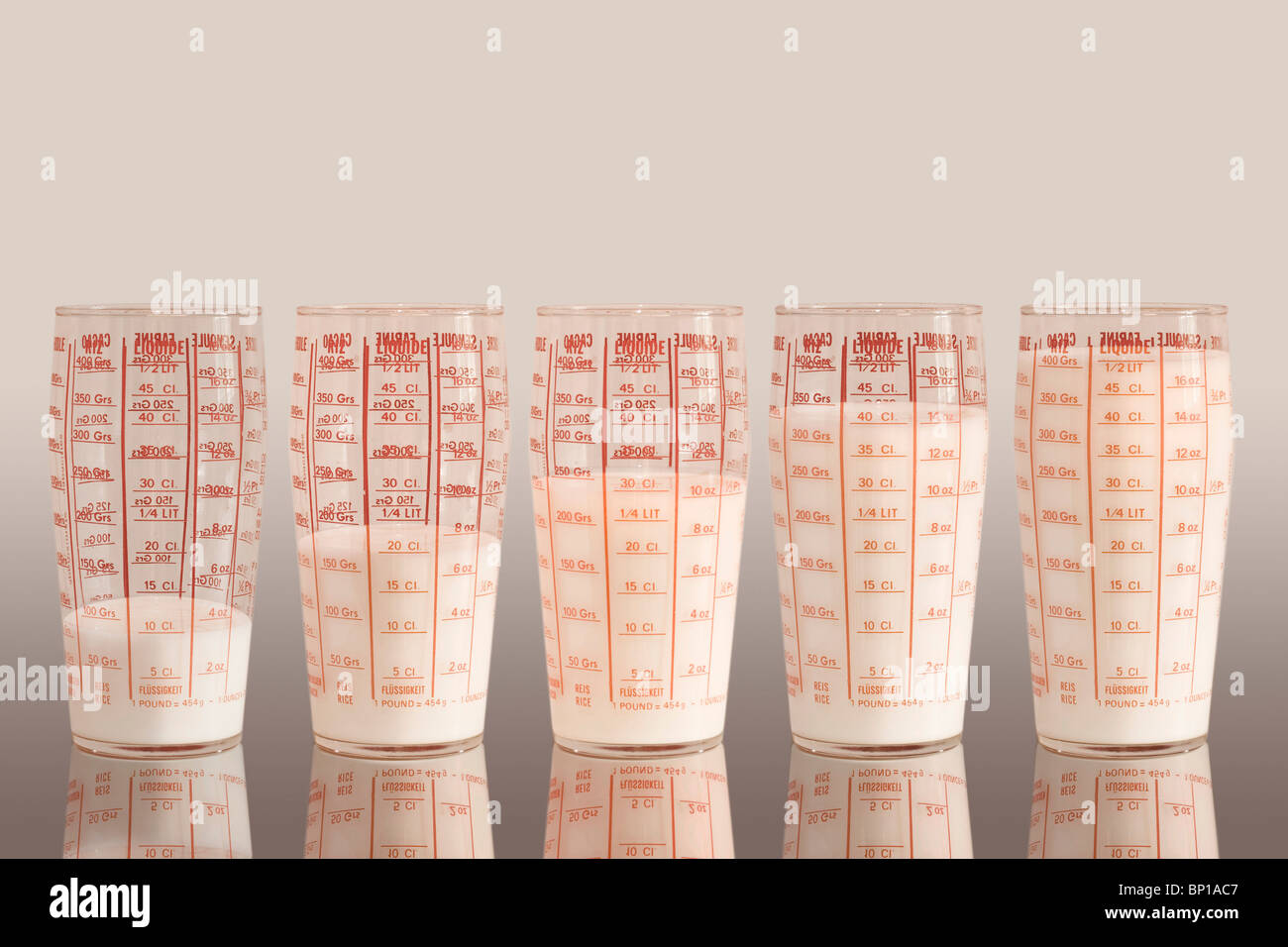 Measuring cups filled with milk stock photo alamy
