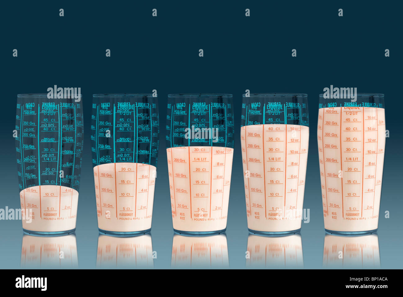 Measuring cups filled with milk Stock Photo - Alamy