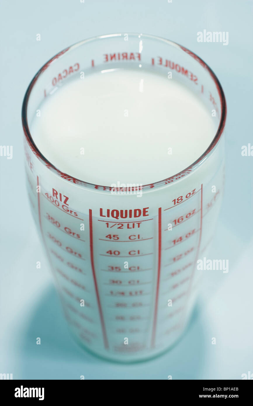 Measuring cup filled with milk Stock Photo Alamy