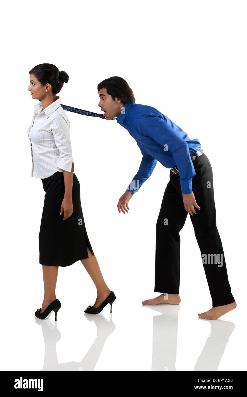 Businesswoman pulling a businessman's tie Stock Photo Alamy