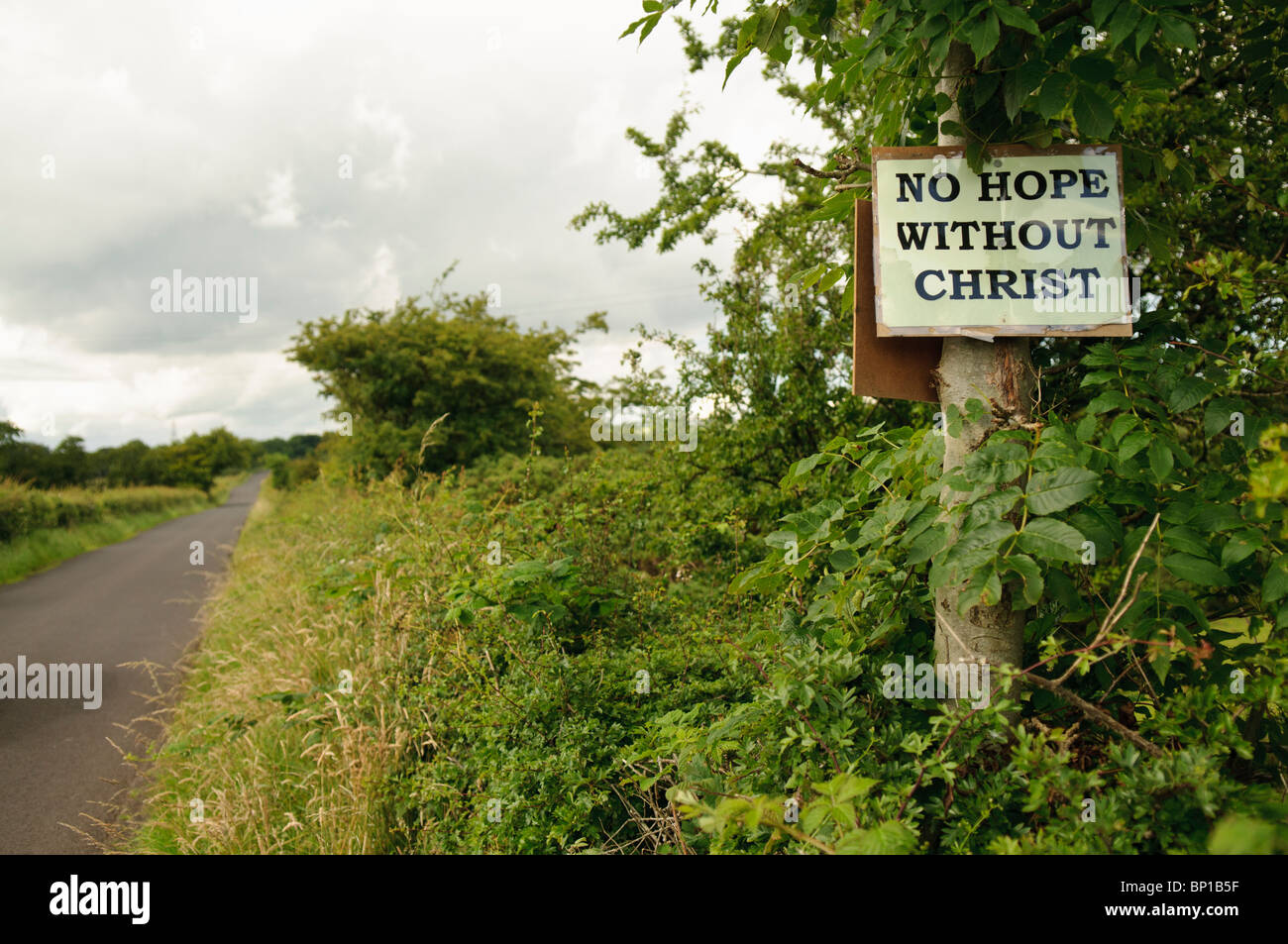 Religious sign nailed to a tree by a country lane.  'No hope without Christ' Stock Photo