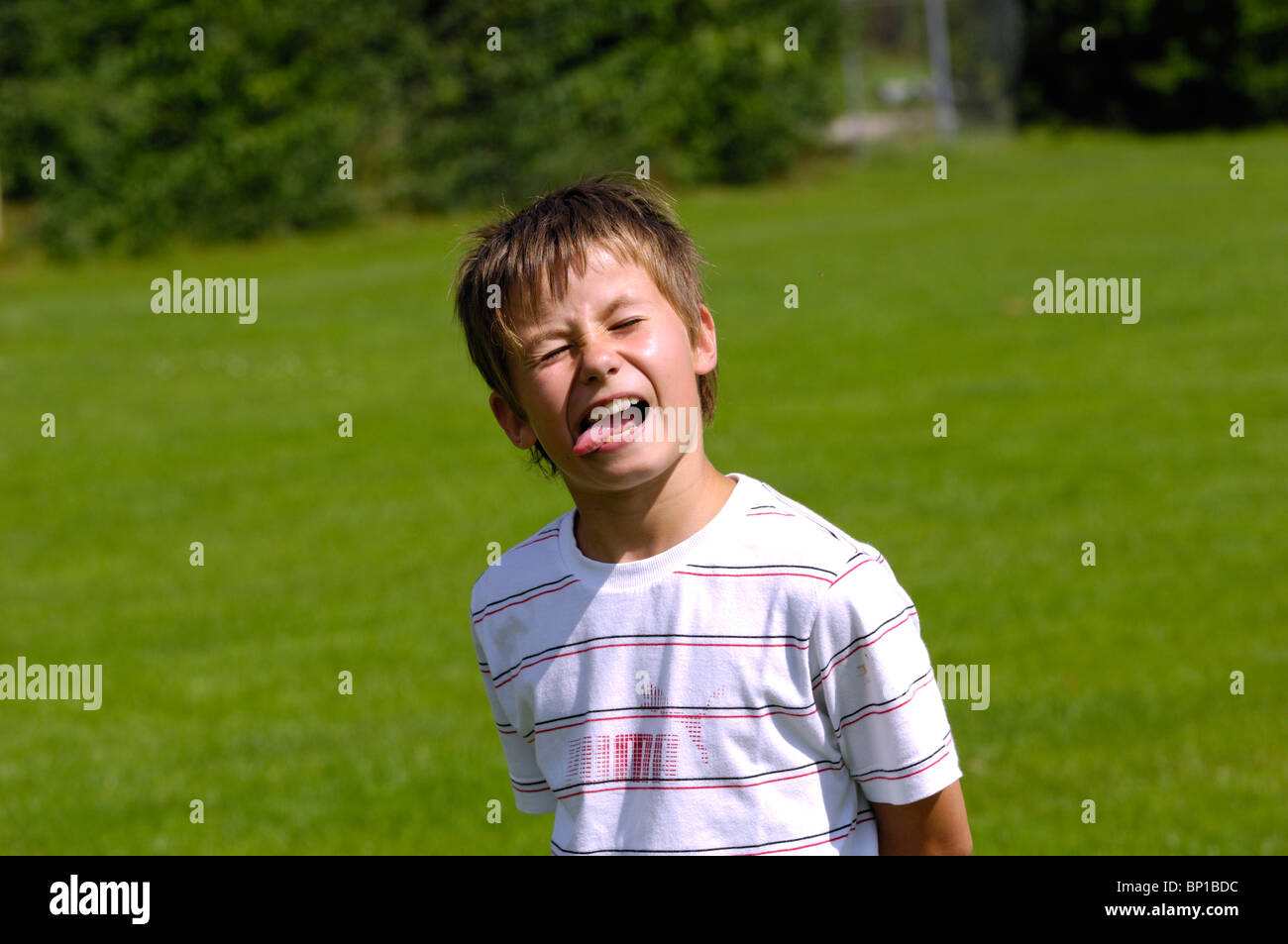 Young Boy sticking his tongue out and making funny faces Stock Photo
